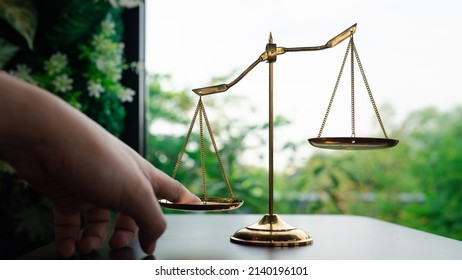 Tip The Scales Of Justice Concept As A The Hand Of A Person Illegally Influencing The Legal System For An Unfair Advantage.	
