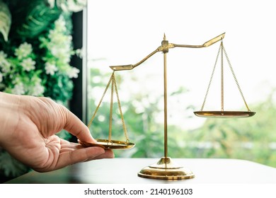 Tip The Scales Of Justice Concept As A The Hand Of A Person Illegally Influencing The Legal System For An Unfair Advantage.	
