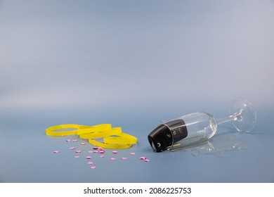 Tipped Over Glass Of Sparkling Wine With Black Car Key In The Glass, Confetti And Streamers On The Table, No Alcohol Behind The Wheel, Risk Of Accident