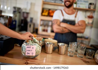 Tips jar - Money left for happy employee in cafe store.