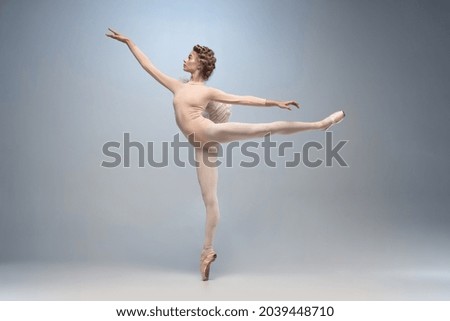 Tips on toes. Young graceful ballerina dancing alone isolated on white gray background. Art, motion, action, flexibility, inspiration concept. Classiacal ballerina in pointe shoes and angel wings