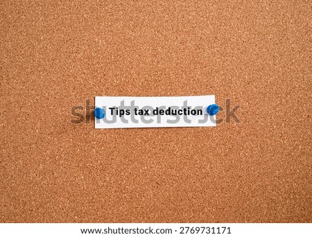 Tips tax deduction label note pinned on cork bulletin board. USA gratuity income tax policy finance concept