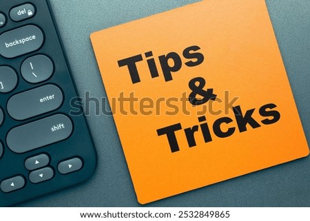 Tips and Tricks text on wood pad on the desk, with computer keybord