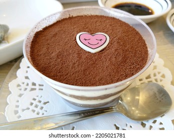 Tiramisu Dessert Served In A Cup And Has A Cartoon Heart On Top.