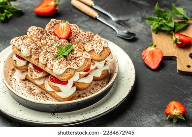 Tiramisu. Homemade tiramisu cake with fresh strawberry, mascarpone and mint. Tiramisu portion on plate. top view. place for text.