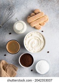 Tiramisu Ingredients. Egg Free Recipe. Mascarpone Cheese In Ceramic Bowl, Coffee Glass, Cocoa Powder, Lady Fingers Cookies, Sugar, Heavy Cream, Whisk And Textile. Сoncrete Background. Top View Food.
