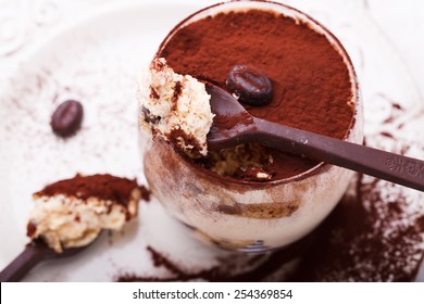Tiramisu, traditional Italian dessert in a glass,with chocolate spoons.selective focus - Shutterstock ID 254369854