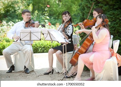 Tiraspol, Moldova - 09/07/2019 - A Musical String Quartet Plays At A Wedding. Cellist And Violinist At An Outdoor Wedding Ceremony