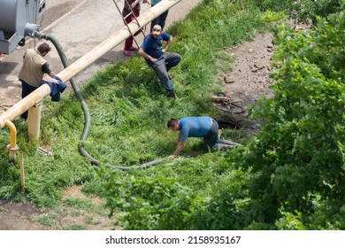 Tiraspol, Moldova - May 17, 2022: Male workers fixes a break in a water supply and sewerage pipe. Accident on the line of urban infrastructure. Poor quality water pipes. Unrecognized Transnistria.