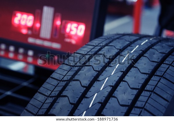 Tire check on\
balancing machine.Blue toned\
photo
