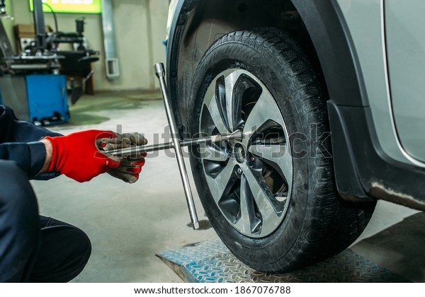 the tire\
fitting process in the garage, the worker removes the wheel, makes\
the tire fitting and puts the\
wheel