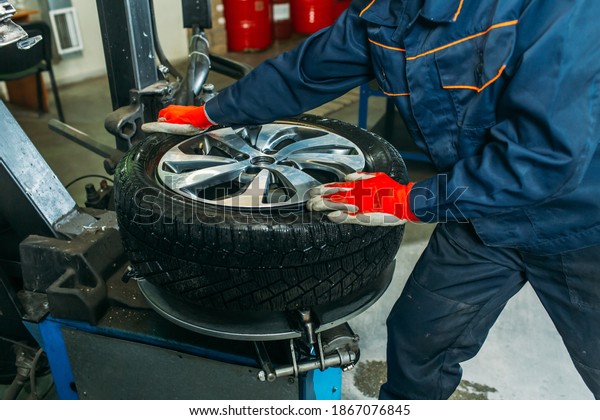 the tire\
fitting process in the garage, the worker removes the wheel, makes\
the tire fitting and puts the\
wheel