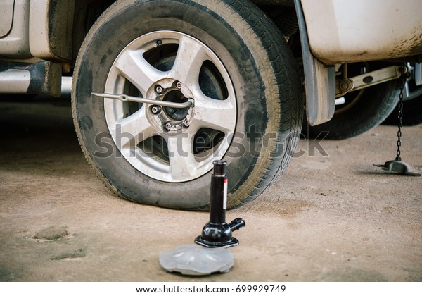 Tire leak car. Tire leakage is doing to\
remove the car tire leak. Rural children help change the tire to\
leakage to grandmother.