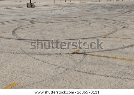 Tire marks create patterns on empty parking lot surface