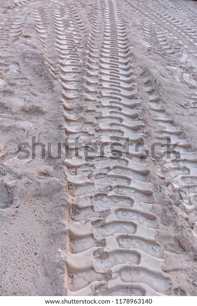 Tire marks in the\
sand of construction yard