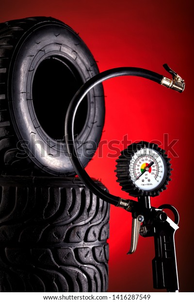 tire pressure\
gauge on dark background\
close-up