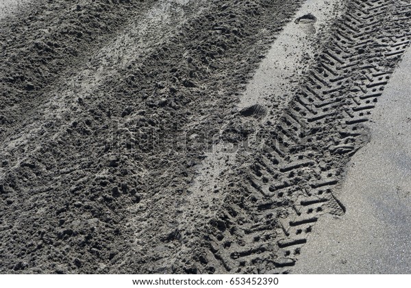 tire print on black sand\
beach