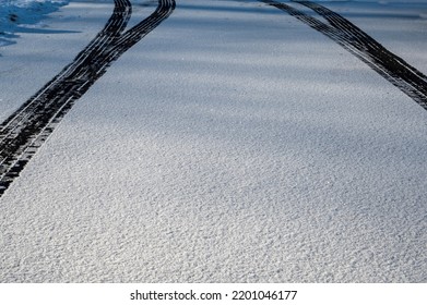 Tire Prints On Road. Abstract Texture And Background Of Car Tire Mark On Snowy Road, Black Tire Mark On Street. Top View, View From Above.