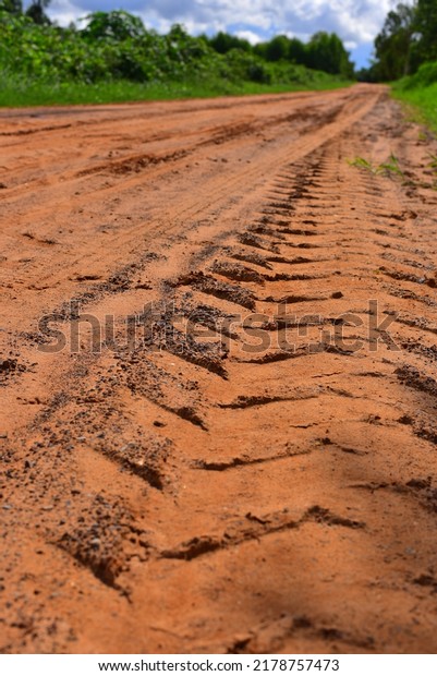 The tire prints at the raw road, on countryside.\
Portrait size
