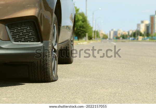 A\
tire puncture in a car, the car is standing at the\
curb