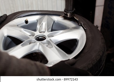 Tire Rotation. Car Mechanic Changing Tire In Car Service