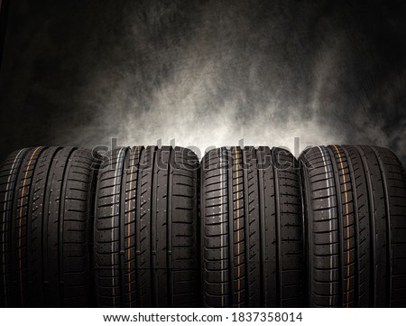 Tire stack background. Car tires on a black background. Four wheels.