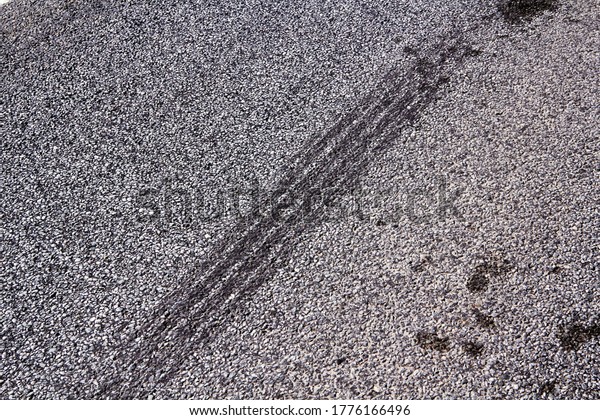 Tire tracks\
on a asphalt road, abstract\
background