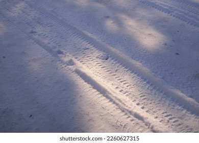 tire tracks in the snow. frozen tire tires in ice. frozen tire tracks. Car tracks on the snow at a frozen lake in Finland, aerial shot. Treads and footprints in snow, city street covered in snow.