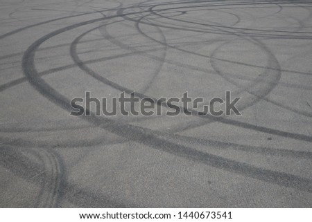 tire tracks. wheel track on asphalt road. asphalt with traces of car wheels. Traces of braking from rubber tyres on cement. Abstract road background with tracks of tires