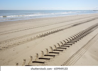 Tire Tread Footprints Of A Tractor On The Sand.