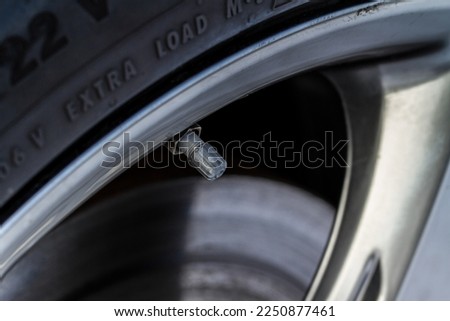 Tire valve cap on modern car wheels. Close up of a new car tire valve. Vent in the wheel of a car.