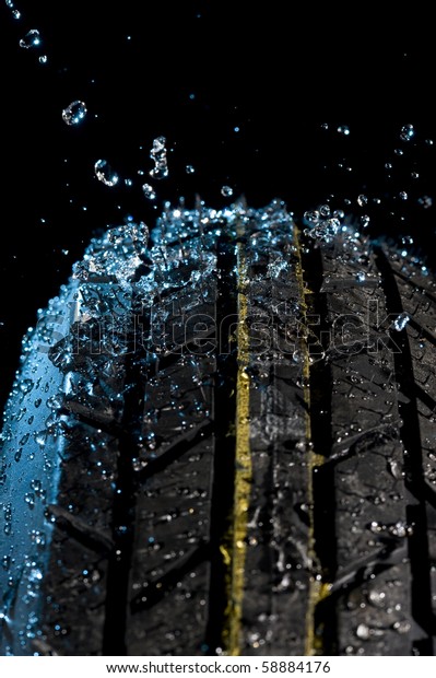 Tire with water\
drops on it black\
background