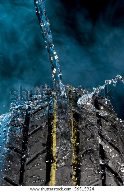 Tire with water\
drops on it smoke\
background