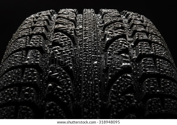 Tire with water\
drops over black\
background