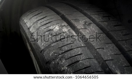 Tire wear concept. Danger of using old car automobile tire drilled with a metal screw nail .