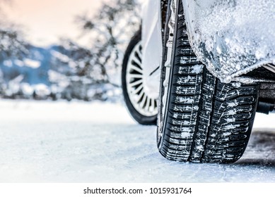 Tire in winter on snow road. Winter tires with car detail.