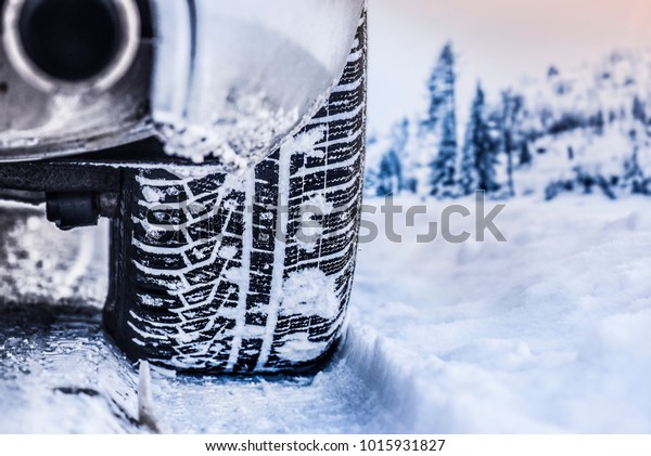 Tire in winter on snow road. Winter tires with\
car detail.
