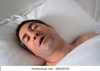 Tired Adult Middle Age Man (male Age 30-40) Snoring In Bed. Health Care And Medical Concept. Real People. Copy Space 