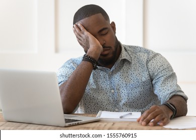 Tired African American Male Student Feel Fatigue Having Sleep Deprivation Overwhelmed With Laptop Working, Exhausted Biracial Man Fall Asleep Studying On Computer Preparing For Exam At Home