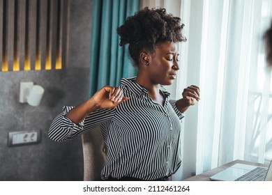 Tired African American Millennial Female Worker Sit At Desk Touch Back Suffer From Lower Spinal Spasm, Hurt Unhealthy Biracial Woman Stretch Have Strong Backache, Incorrect Posture Concept