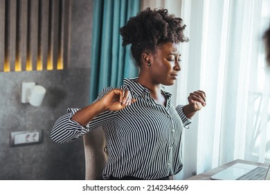 Tired African American Millennial Female Worker Sit At Desk Touch Back Suffer From Lower Spinal Spasm, Hurt Unhealthy Biracial Woman Stretch Have Strong Backache, Incorrect Posture Concept