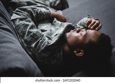 Tired African American Soldier In Military Uniform Sleeping In Sofa At Home