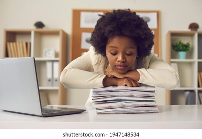 Tired african american woman office worker freelancer sleeping leaned chin on paperwork finance sheet document stack sitting at desk. Overworked, hard workload, burnout and exhaustion concept