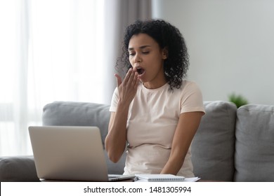 Tired african American young woman sit on sofa yawn feel fatigue working long on laptop, exhausted black millennial girl sigh having sleep deprivation, overwhelmed with computer studying at home - Shutterstock ID 1481305994