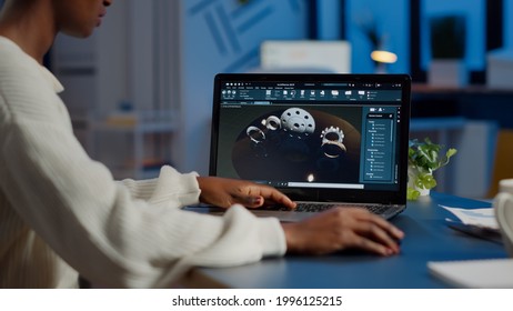 Tired african designer engineer analyzing new prototype of 3D model of industry product, working overtime. Industrial female worker studying gears idea on laptop showing cad software on device display