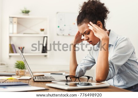 Tired african-american business woman with headache at office, feeling sick at work, copy space
