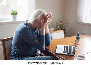Tired aged man massaging eyes working too long at laptop, senior male feel exhausted suffer from headache after using computer, elderly having blurry vision or dizziness from pc screen