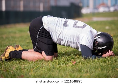 A tired american football player resting after hard training at field - Powered by Shutterstock