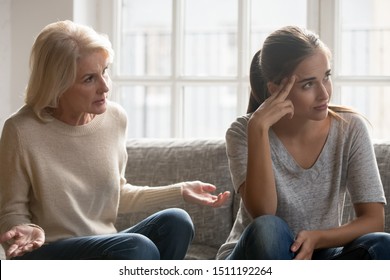 Tired Annoyed Millennial Woman Lose Patience Ignore Senior Anxious Mom Talking Lecturing At Home, Elderly Middle-aged Authoritative Mother Sit On Couch Scolding Moralizing Grownup Adult Daughter