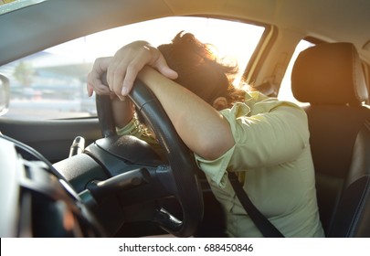 Tired Asian Business Woman In Green Shirt Sleeping On Steering Wheel While Driving Car Go To Office In The Morning. Life Of Exhausted Female Hard Work And Overtime Concept.